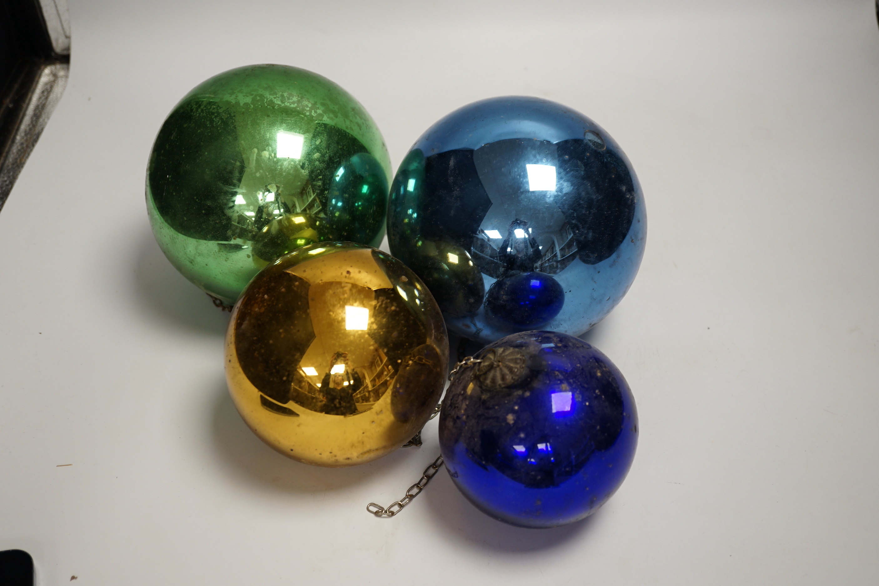 Four various metallic coloured witch’s balls, (dark blue, green, gold and light blue)